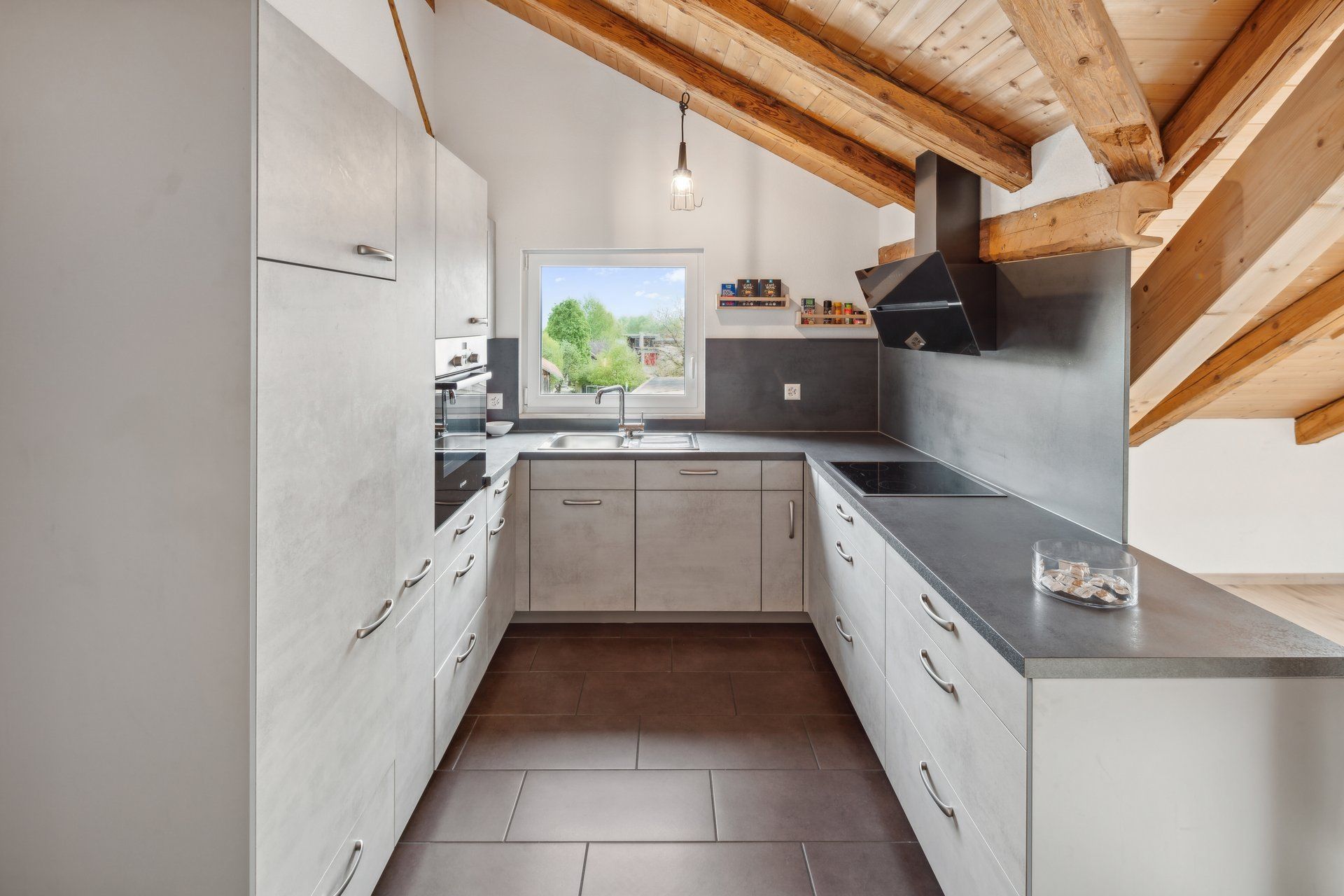 A kitchen with white cabinets and a wooden ceiling.