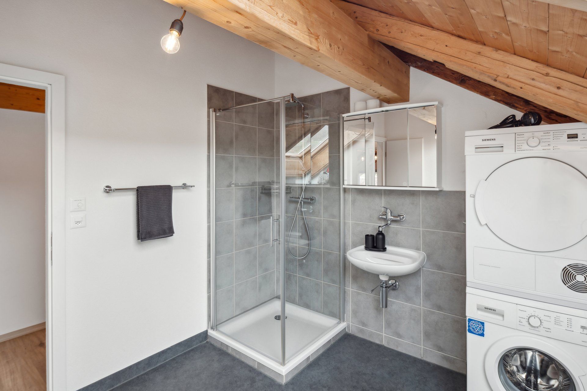 A bathroom with a washer and dryer stacked on top of each other.