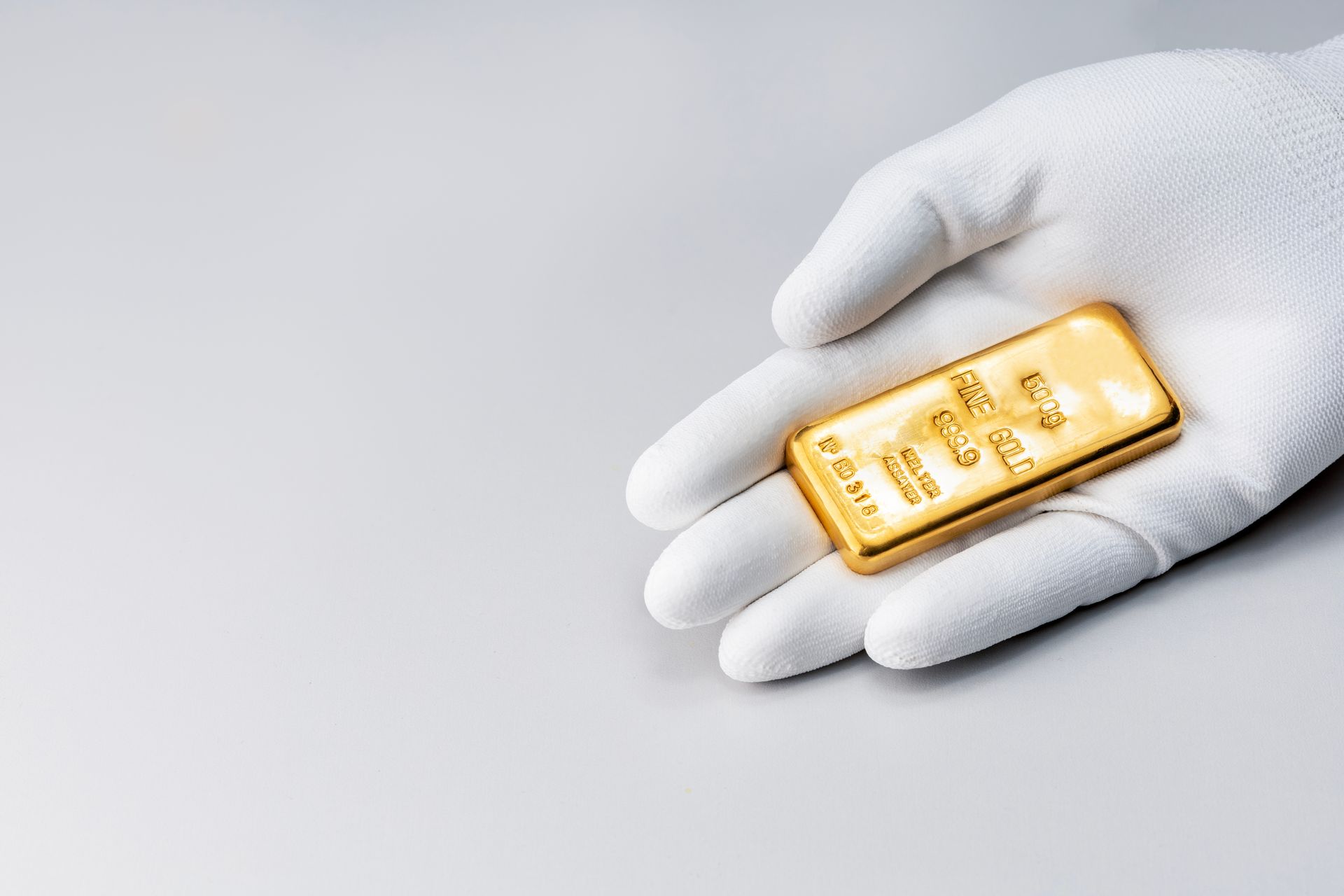 Lingot d'or dans une main gantée