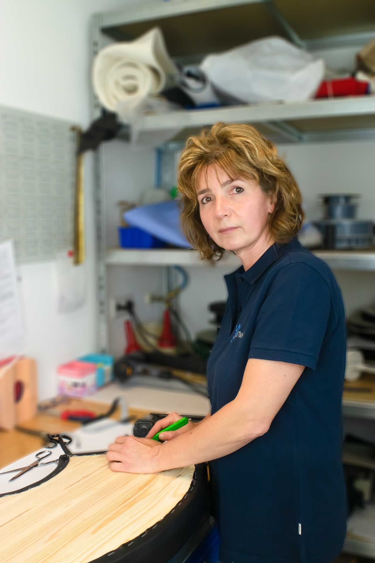 Eine Person sitzt auf einer Bank, trägt bunte Beinprothesen und sieht ein Geländer und die Stadt unter sich