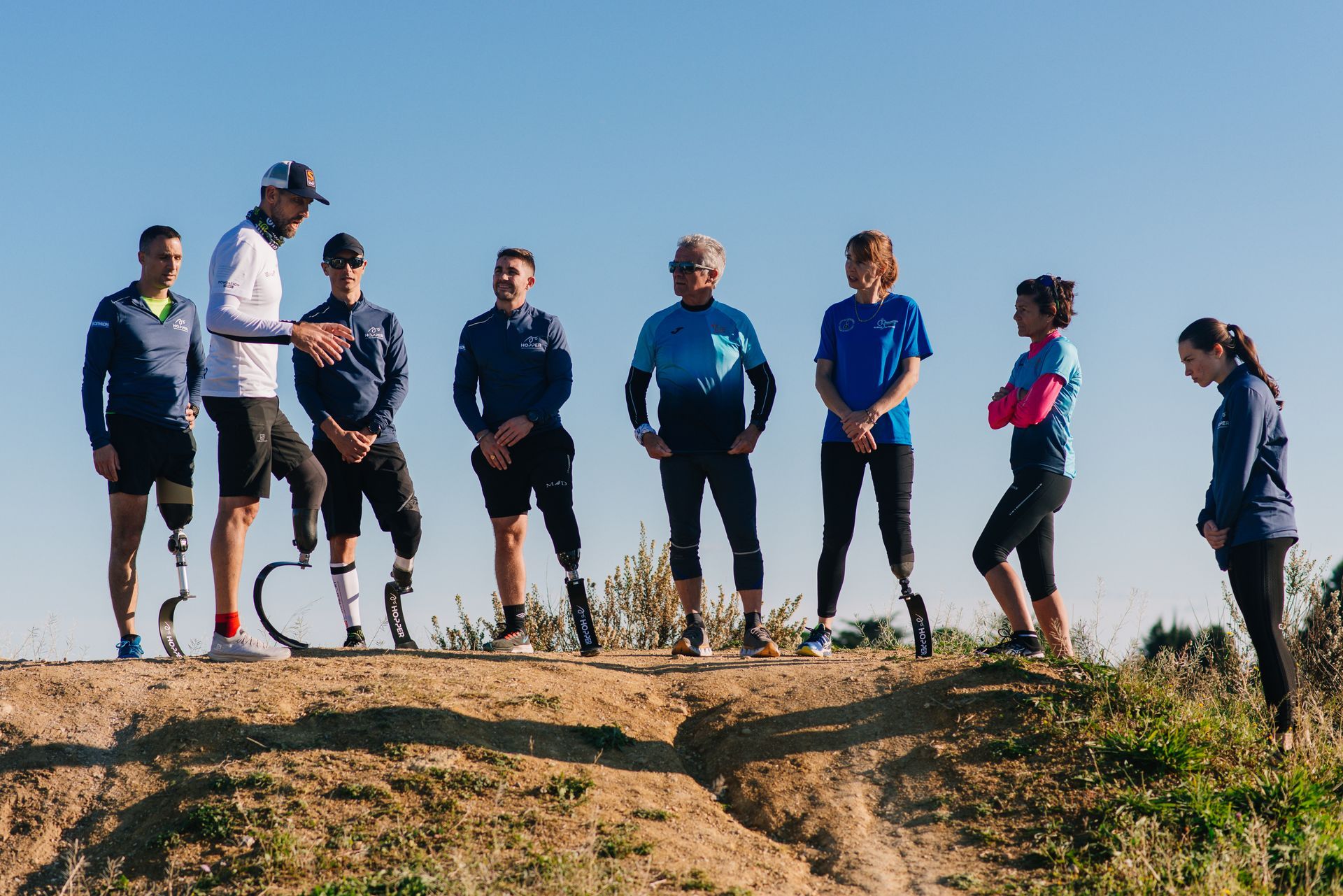 Eine Gruppe von Sportlern steht auf einer Bergkuppe, bereit für einen Wettkampf oder eine Trainingseinheit