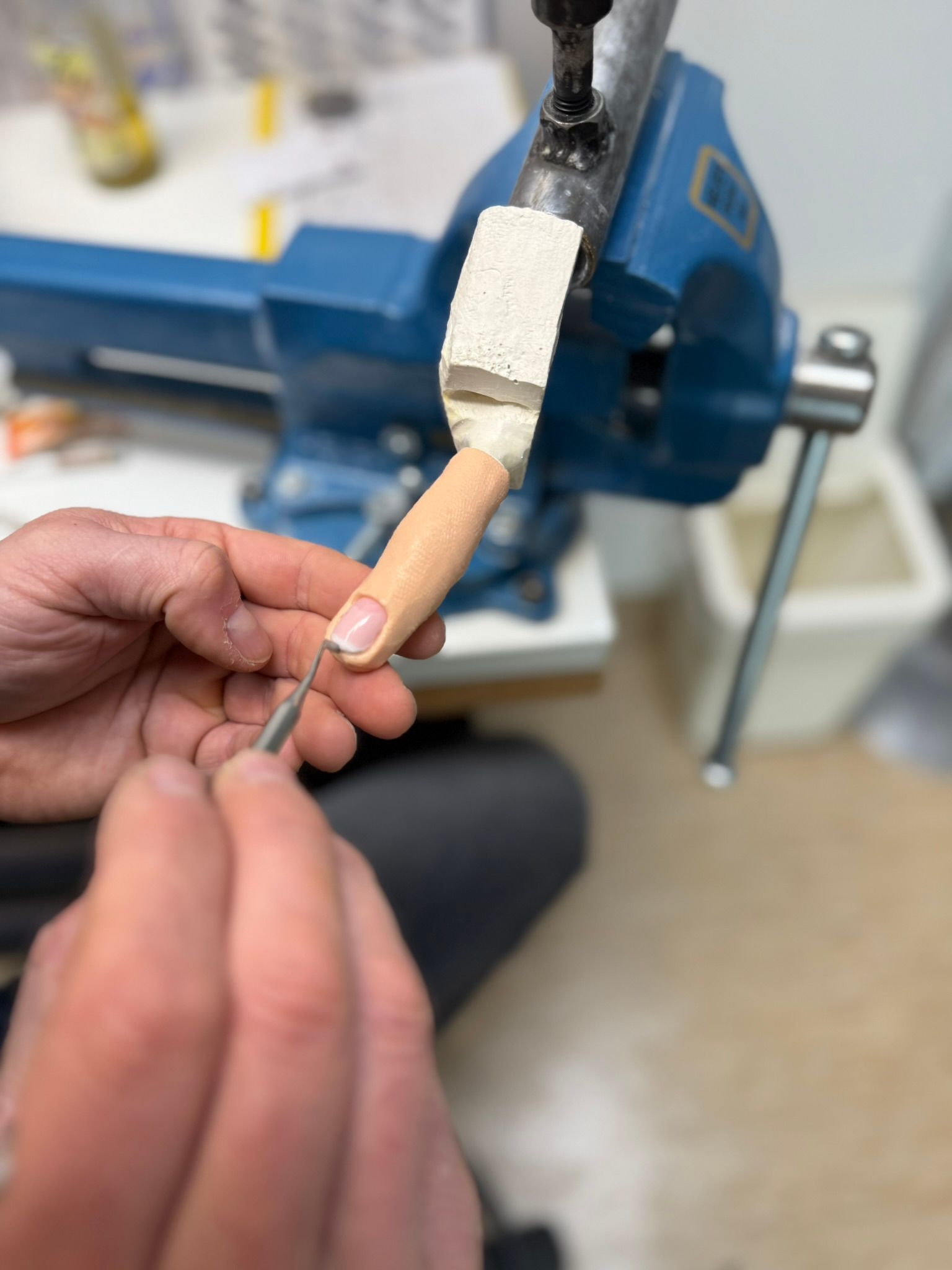 OTec-Mitarbeiter arbeitet mit einer Feile an einem Prothesenfinger