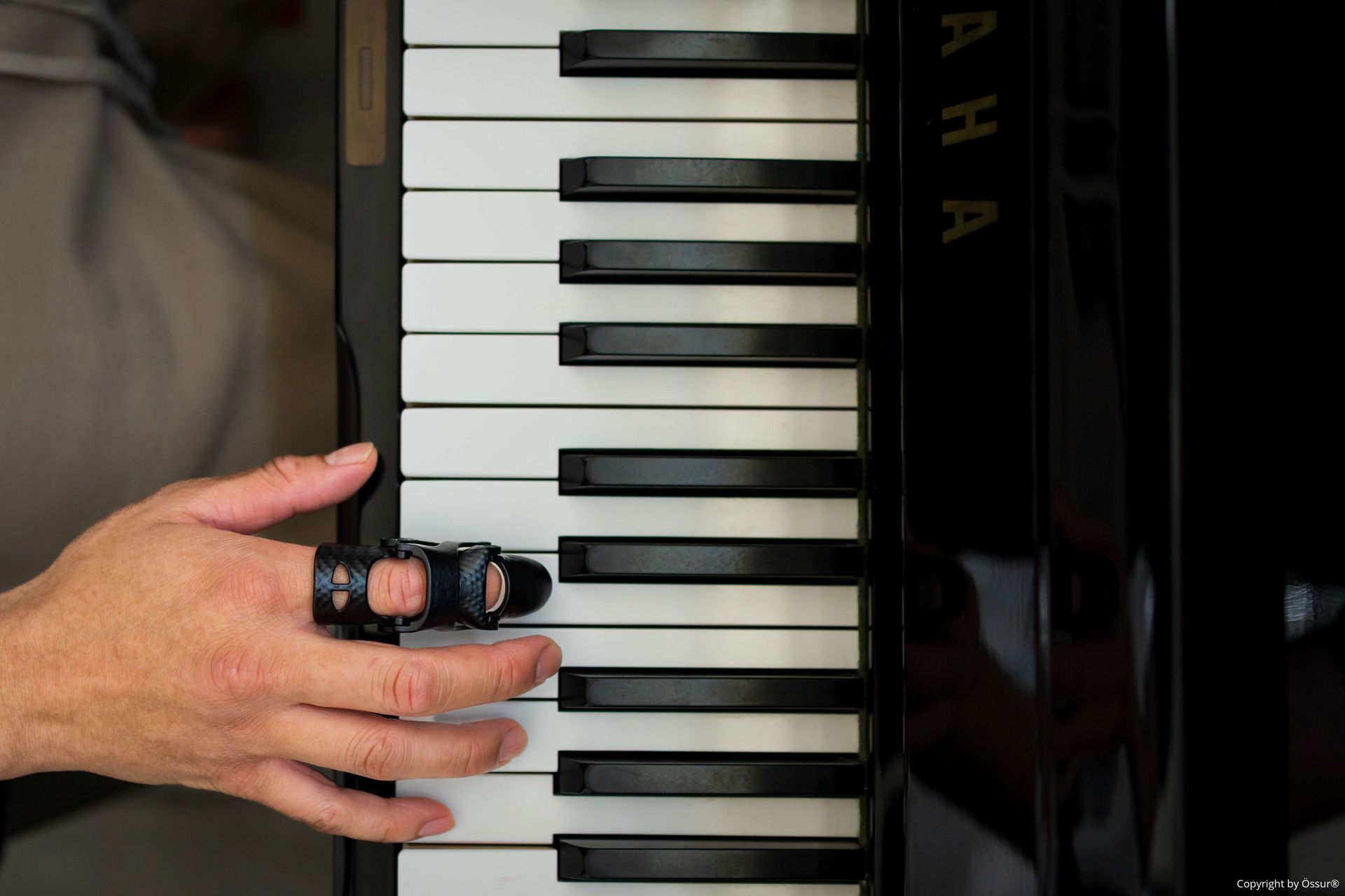 Ein Mann spielt Klavier mit einer Fingerprothese