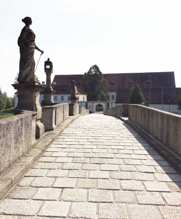 Eine Steinbrücke mit einer Statue an der Seite