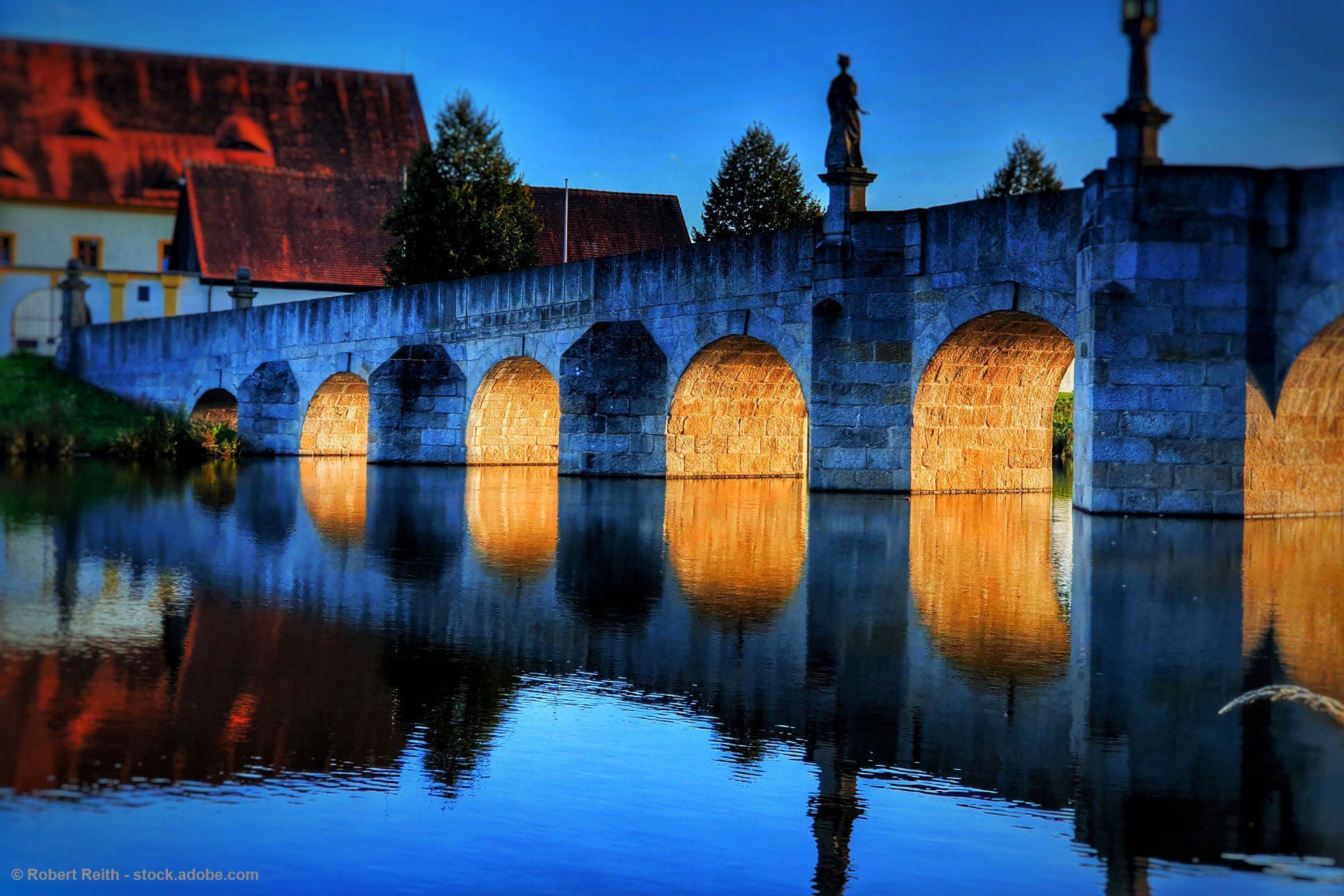 Eine Brücke über ein Gewässer mit einem Gebäude im Hintergrund