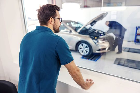 Un homme attend la fin du contrôle technique.