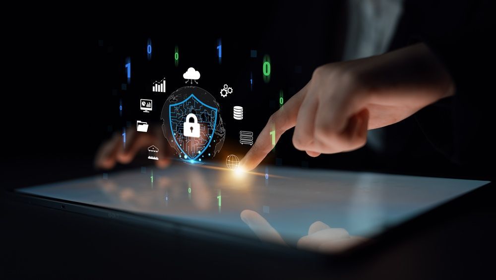 Manos que utilizan una tableta con un escudo de seguridad brillante e iconos digitales sobre la pantalla.