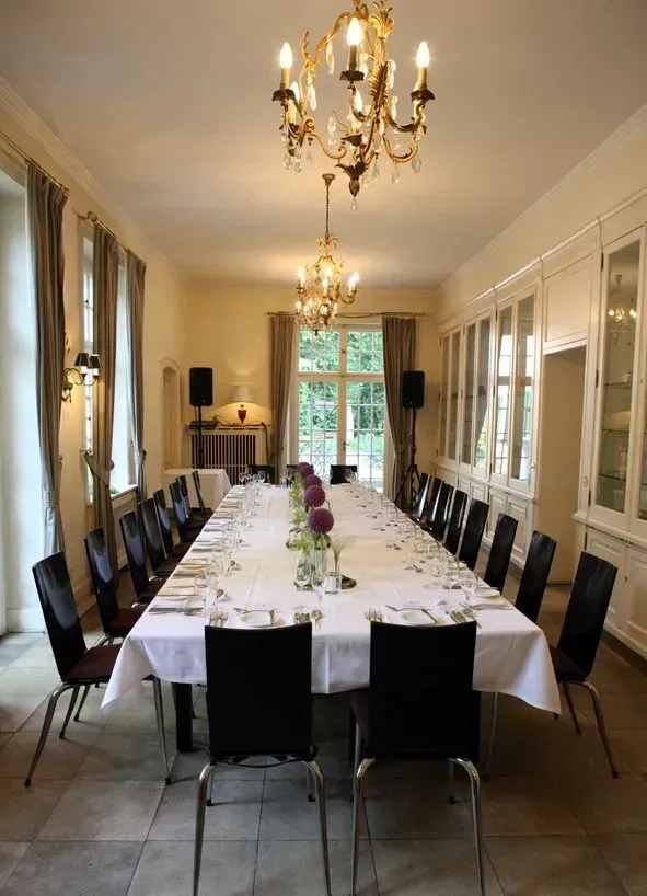 Ein langer Tisch und Stühle in einem Raum mit einem Kronleuchter, Stefanie Cremerius raum-station