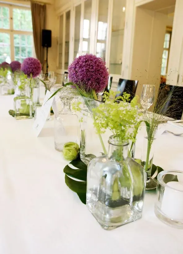 Ein Tisch mit lila Blumen in Vasen darauf