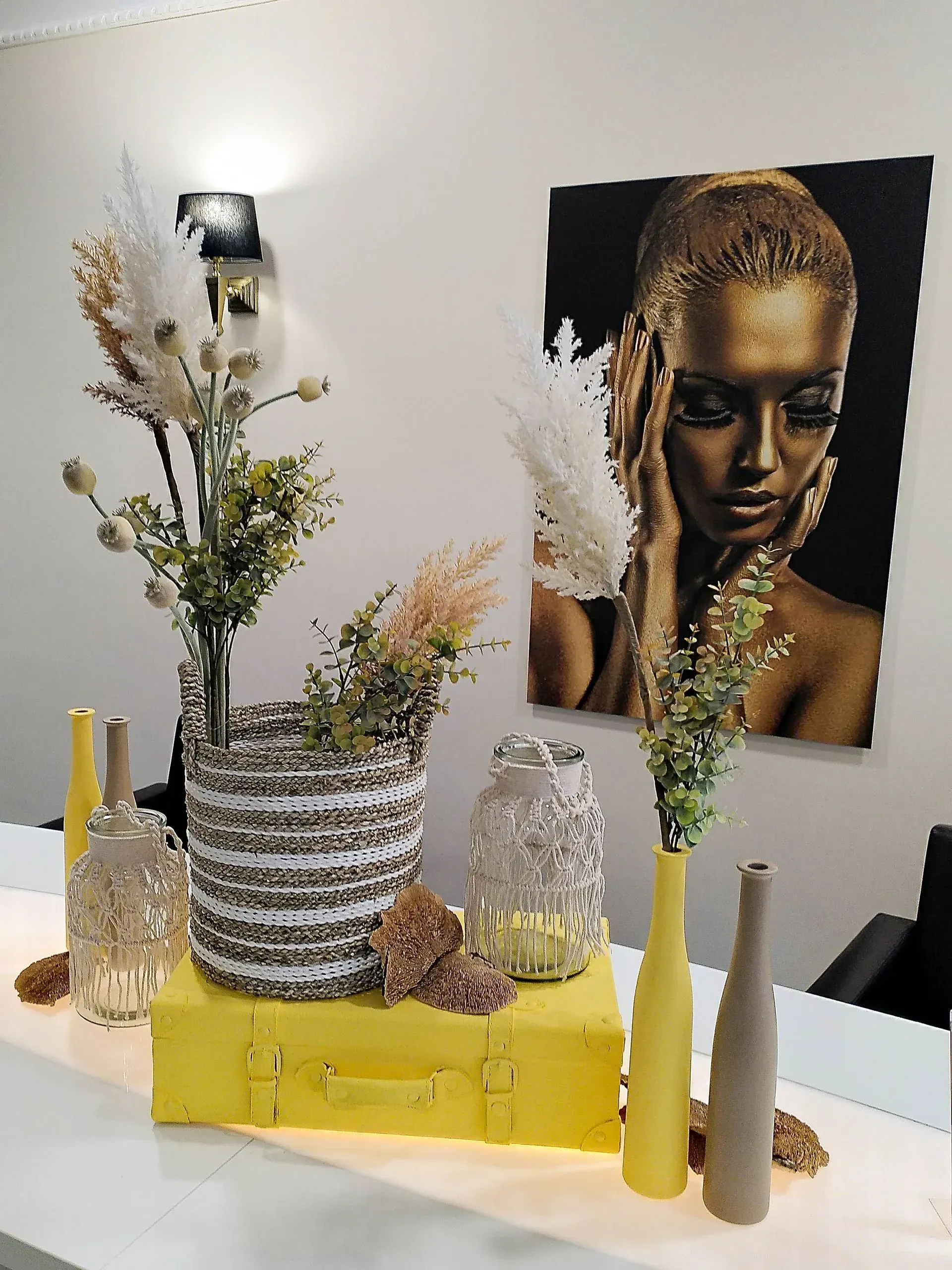 Ein Tisch mit Vasen und einem Frauenbild an der Wand