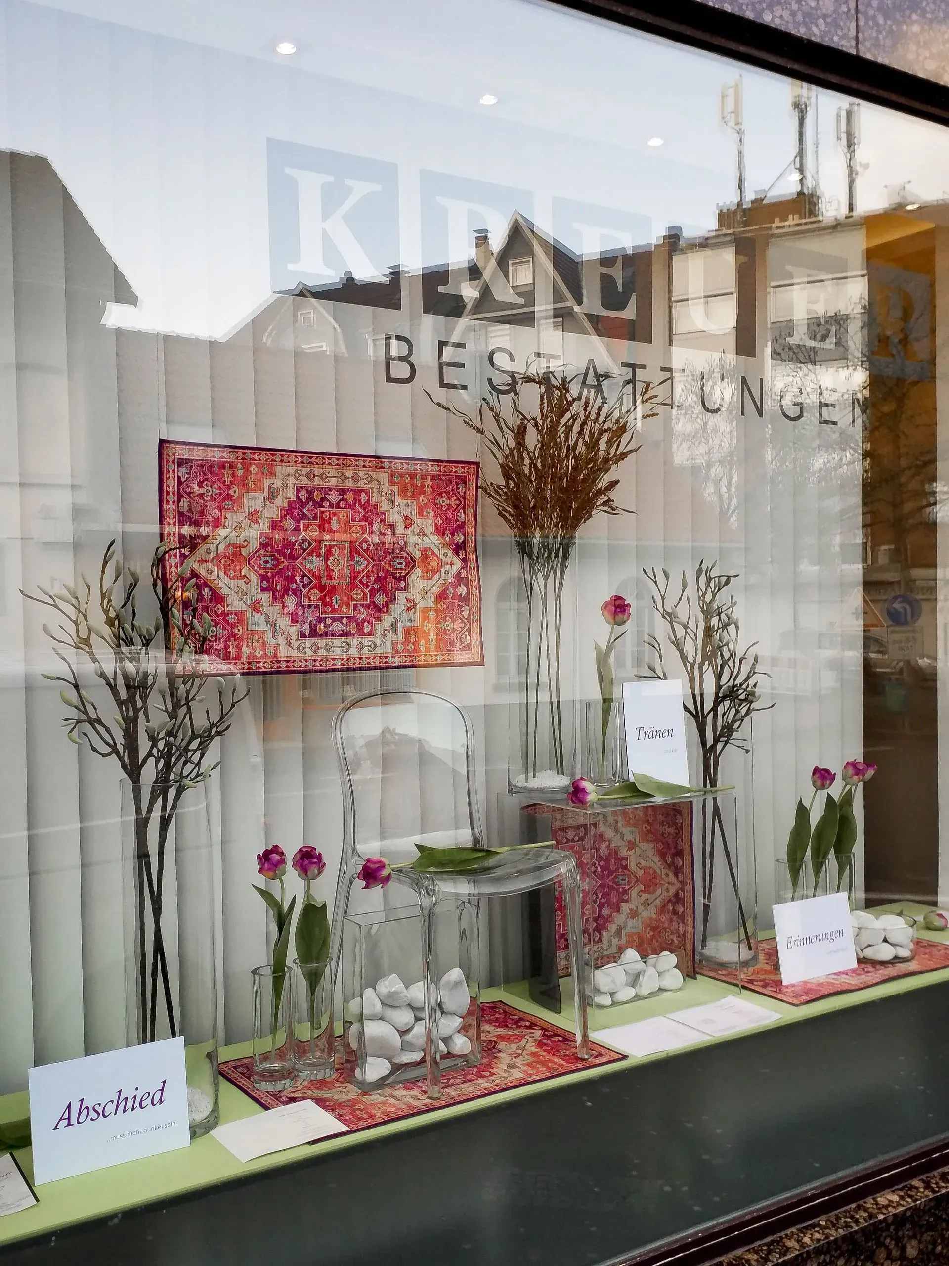 Ein Schaufenster mit Blumen und einem Schild mit der Aufschrift „Jetzt“