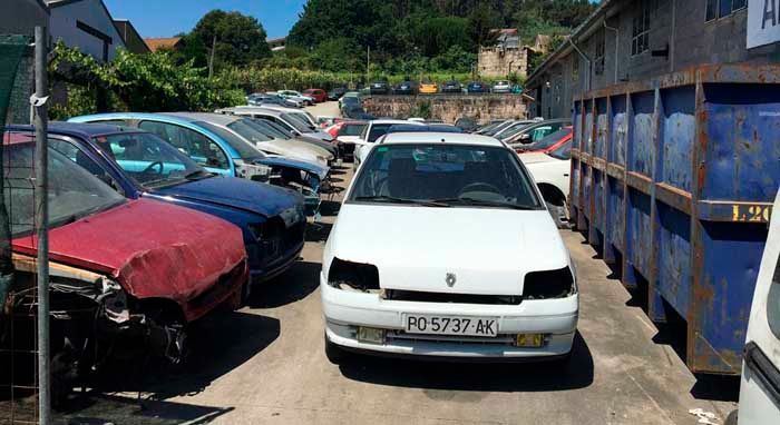 Un coche blanco está aparcado en un montón de coches.