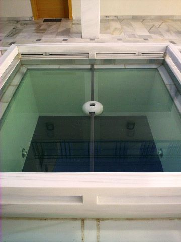 Un piso de vidrio con el reflejo de un edificio en él.