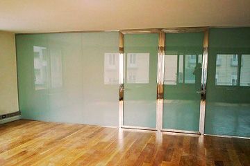 Una habitación vacía con pisos de madera y puertas corredizas de vidrio.