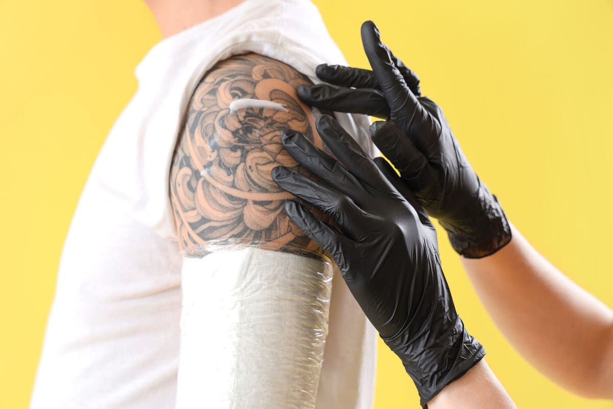 Tatuaje de una máscara de Oni negra y gris con formas similares al agua.