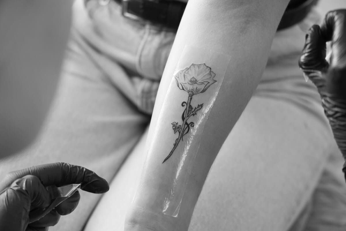Tatuaje en blanco y negro de diseños geométricos y florales en el brazo de una persona.