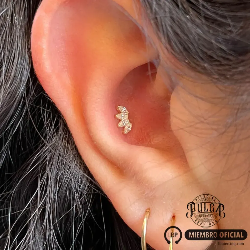 Perfil lateral de una mujer. Fotografía en blanco y negro con tatuaje oscuro en forma de oreja.