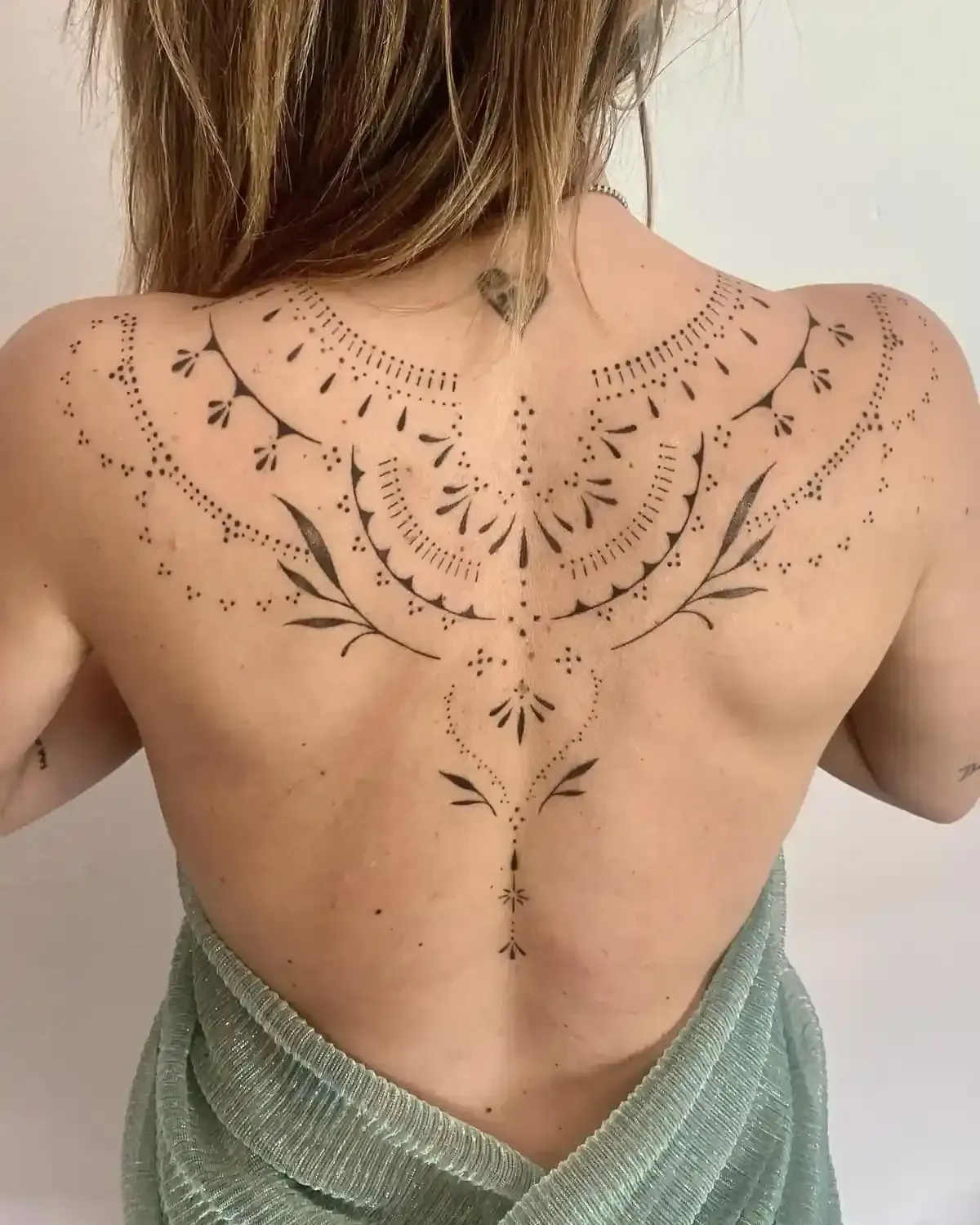 Tatuaje en la espalda de una persona con diseño floral y simétrico.