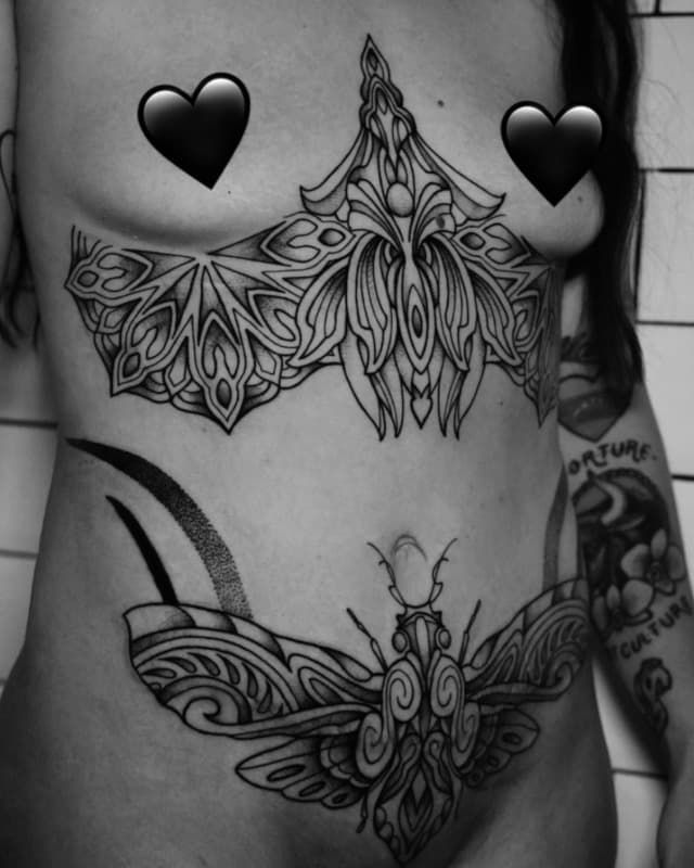 Torso con tatuajes de mariposas negras, incluyendo un gran diseño en el pecho y otro a juego en la parte inferior del abdomen.