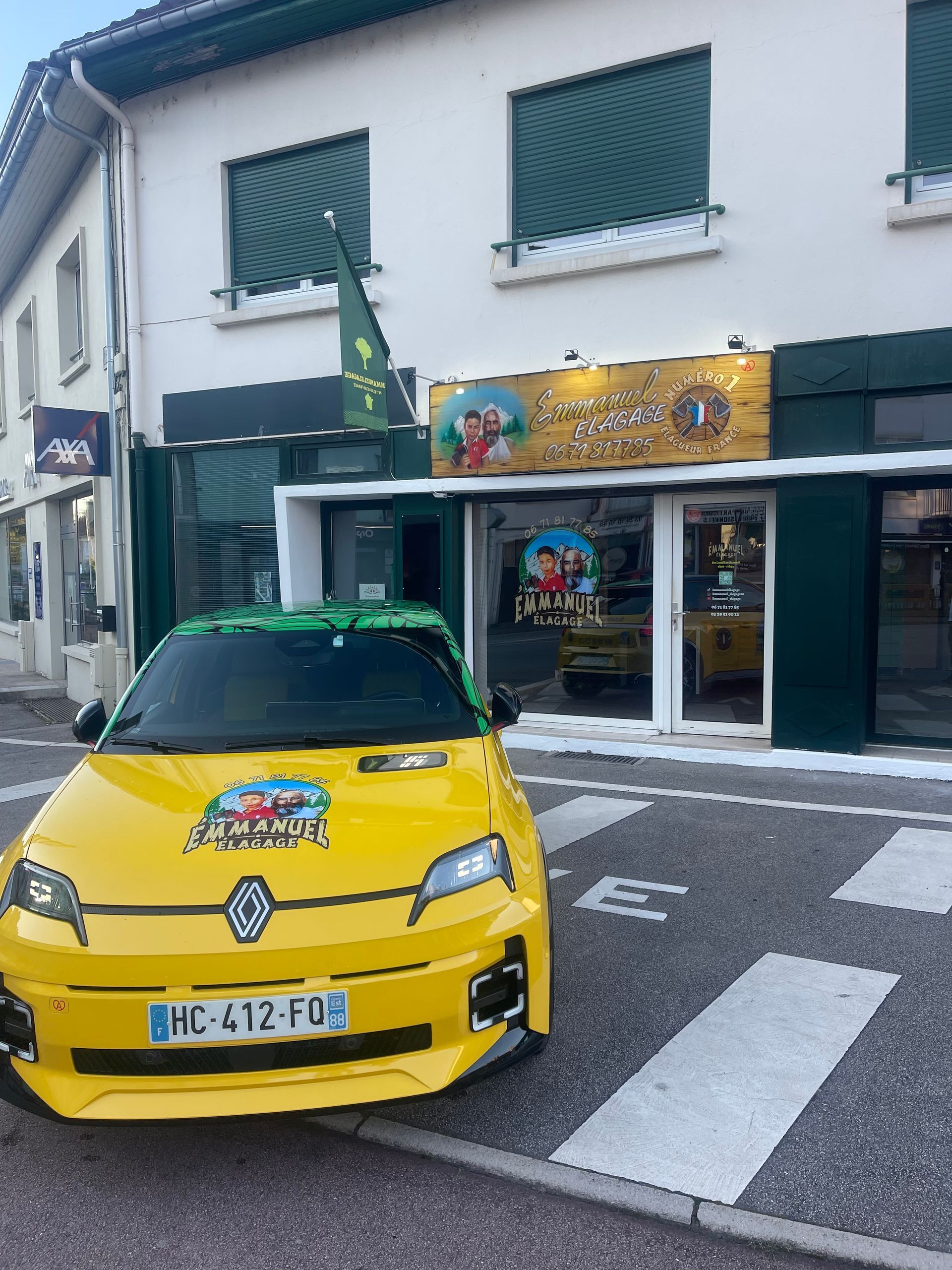 Une voiture jaune devant un magasin à l'enseigne colorée et un bâtiment vert et blanc.