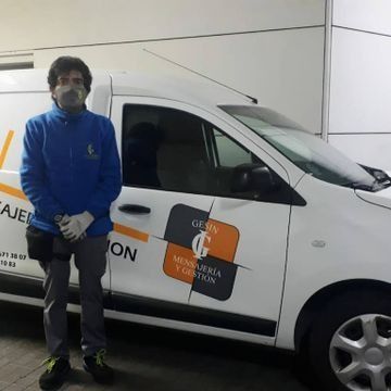 Un hombre con una máscara está parado junto a una camioneta blanca que dice 'caja'.