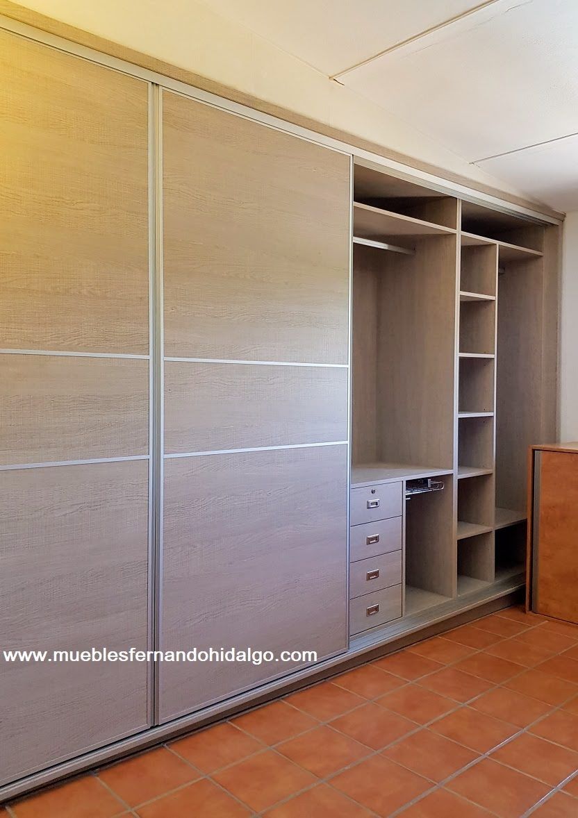 Un vestidor con puertas corredizas y estantes.