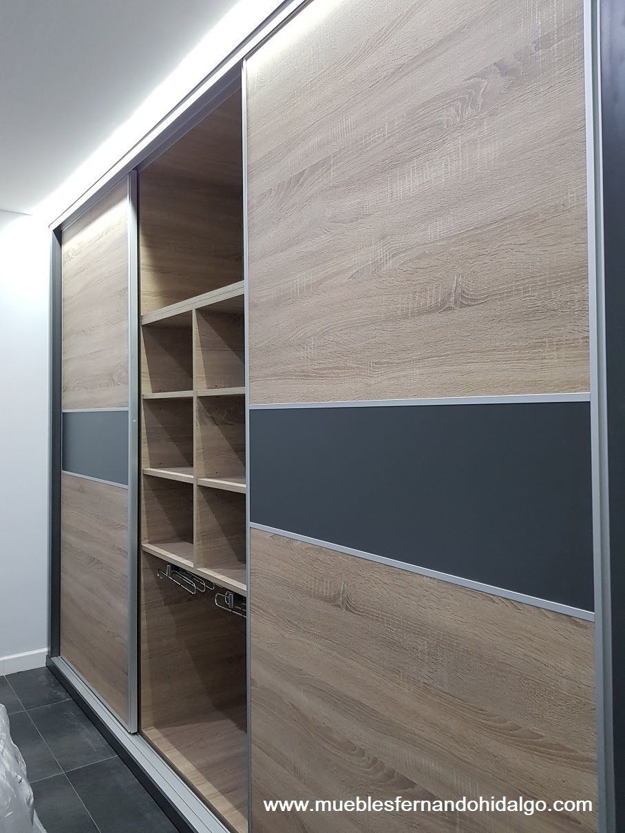 Un armario con puertas corredizas y estantes en un dormitorio.