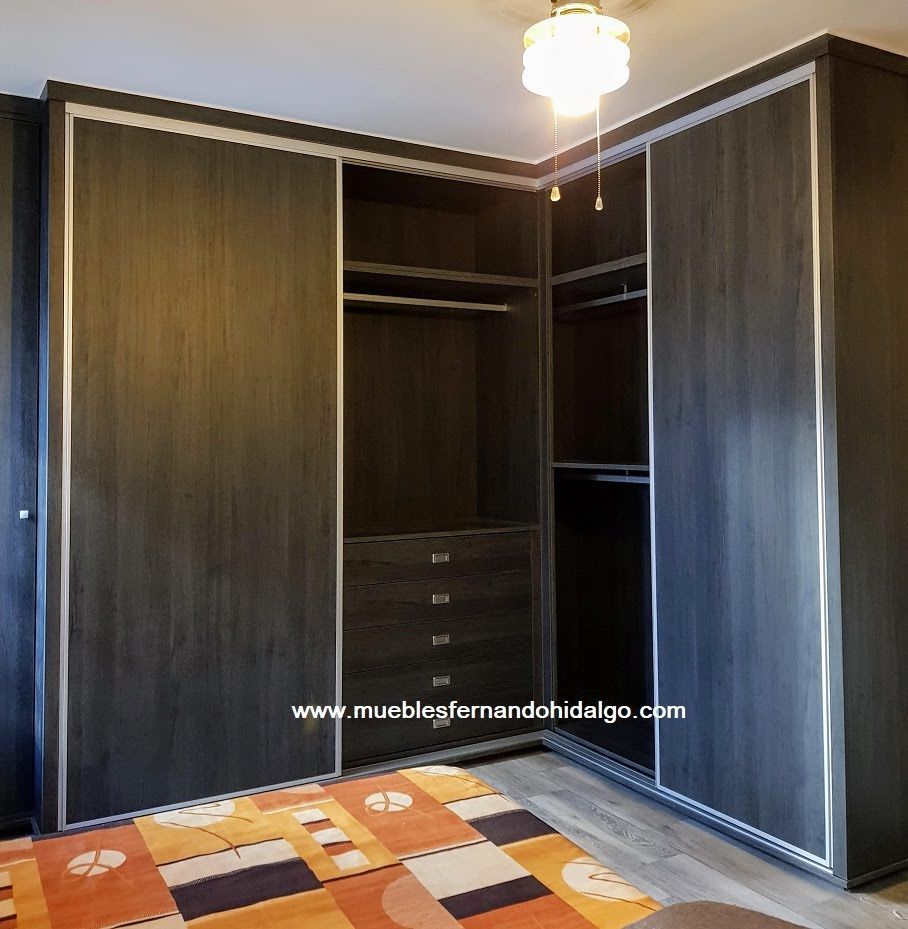 Un armario con puertas correderas y una alfombra en un dormitorio.