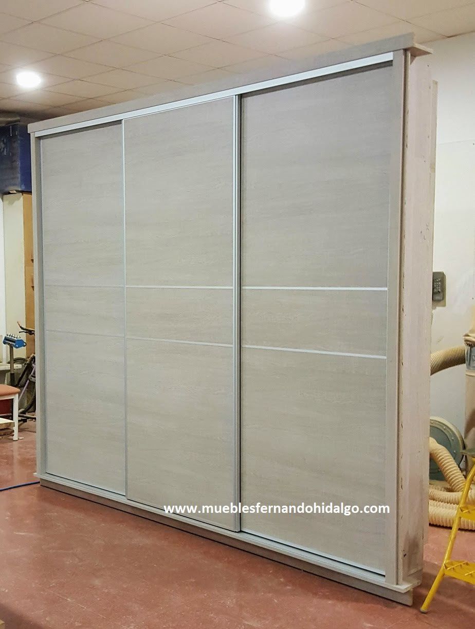 En una habitación hay un gran armario con puertas correderas.
