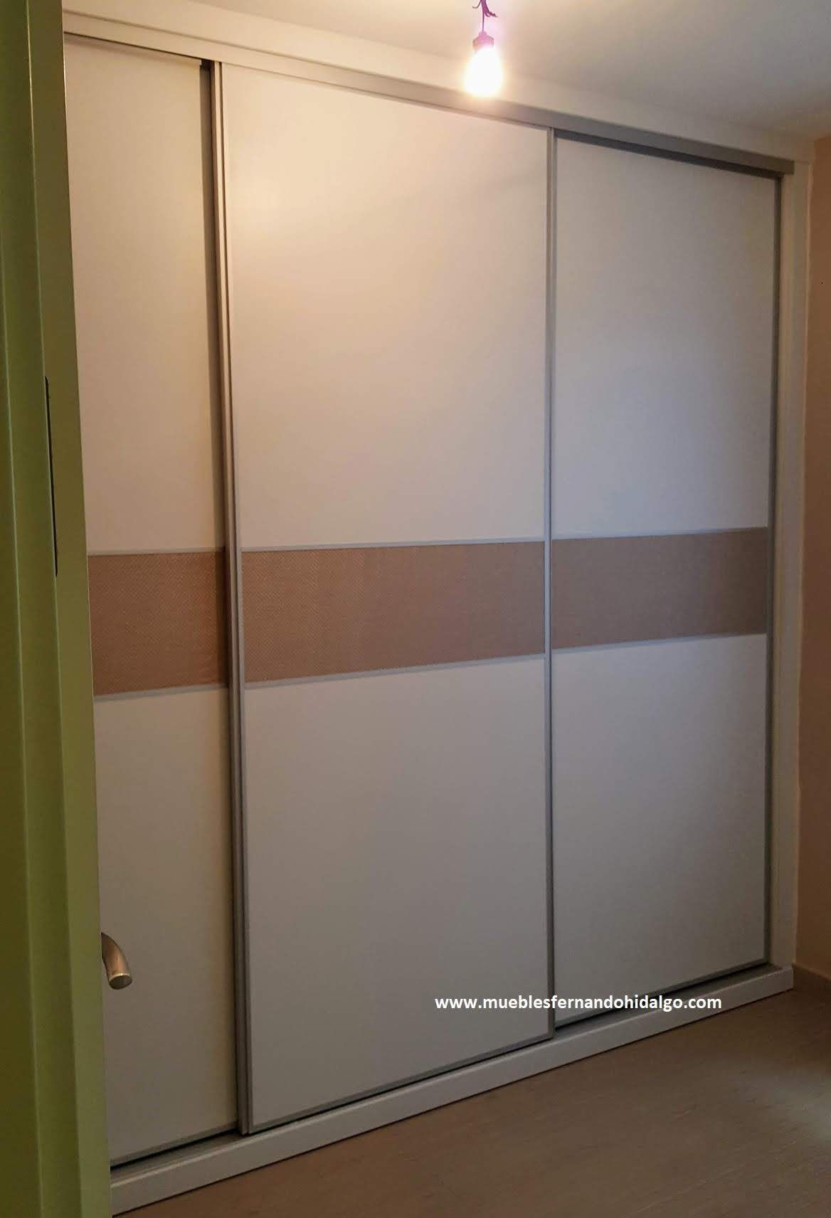 Un dormitorio con un gran armario con puertas correderas.