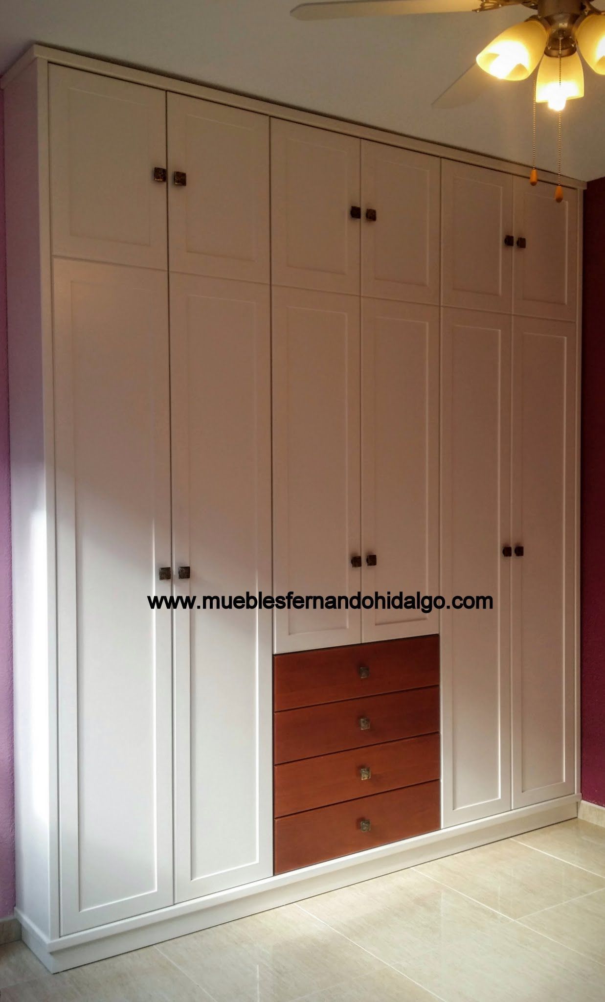 Un dormitorio con armario y ventilador de techo.