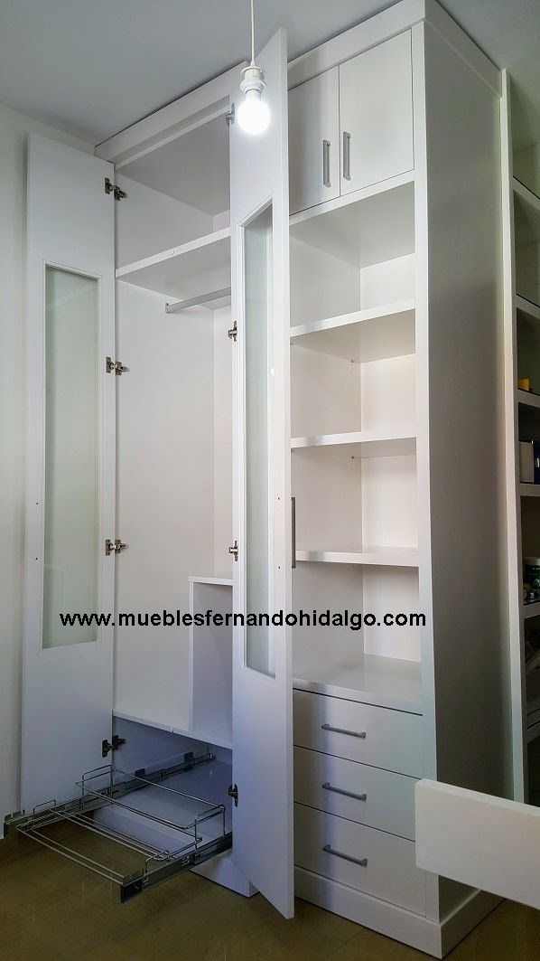 Un armario blanco con las puertas abiertas y una lámpara colgando del techo.