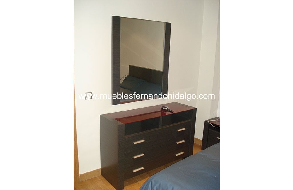 Un dormitorio con una cómoda y un espejo grande.