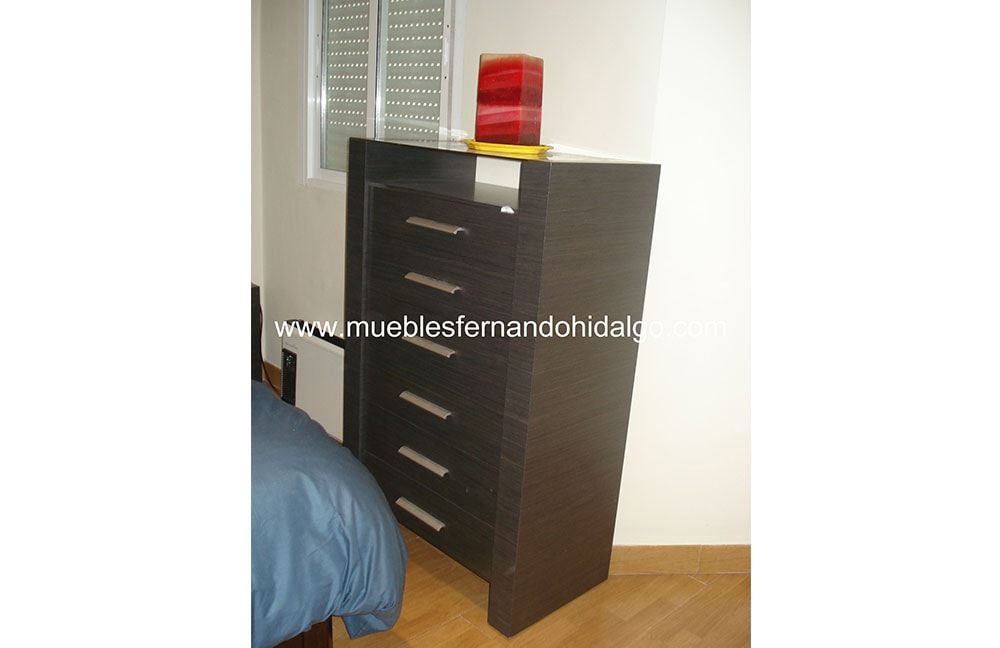 Un dormitorio con una cómoda y una cama.