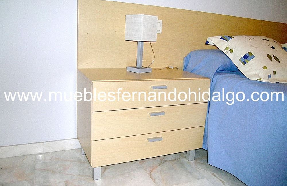 Un dormitorio con cama y mesita de noche con la web www.mueblesfernandohidalgo.com