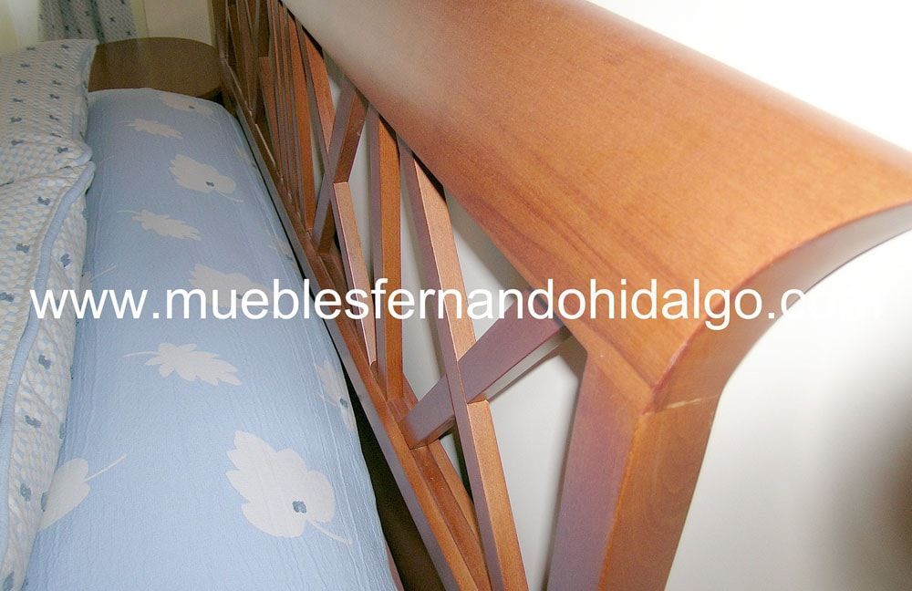 Una foto de una cama de madera con la pagina web www.mueblesfernandohidalgo.com