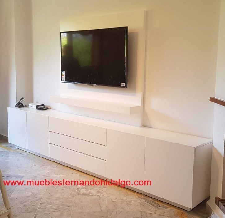 Una sala de estar con un televisor de pantalla plana montado en la pared.