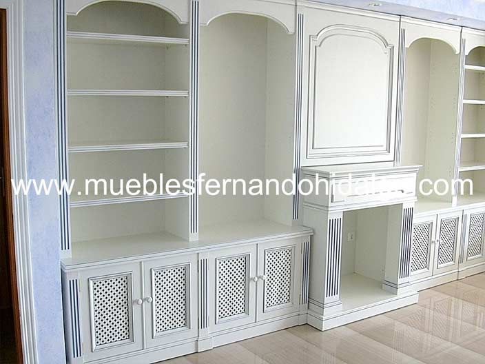 Una habitación con muchos estantes y armarios blancos.