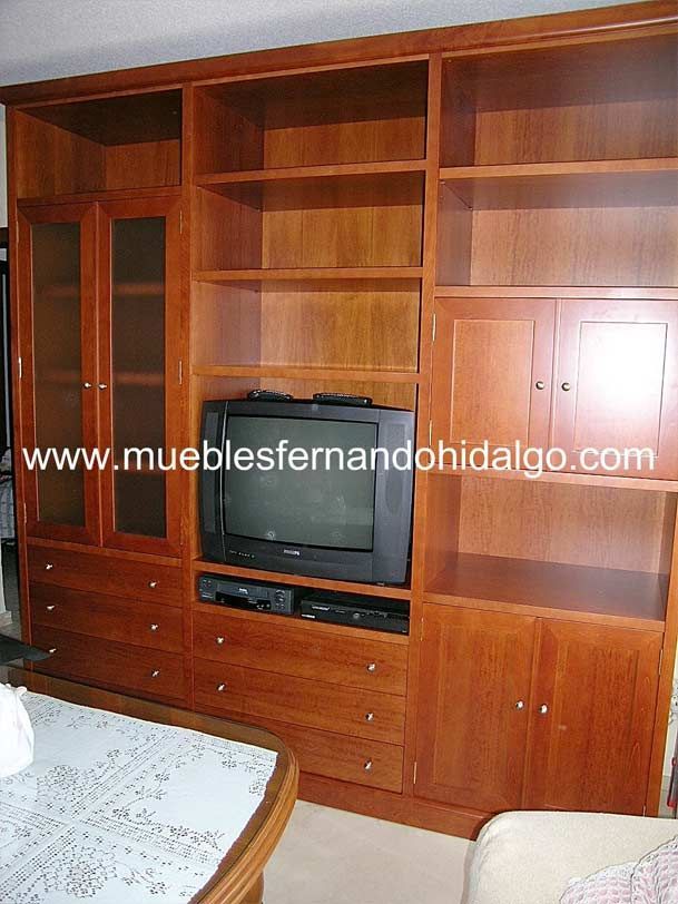 Un centro de entretenimiento de madera con tv de pantalla plana y el sitio web www.mueblesfernandohidalgo.com