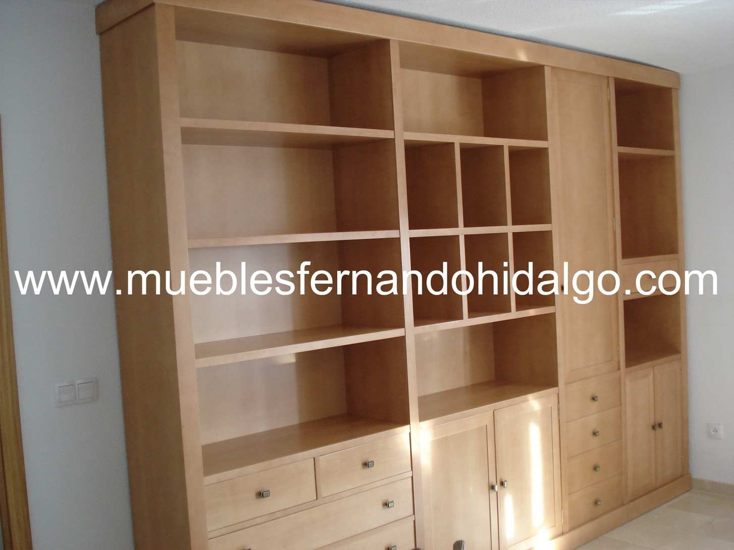 Una gran librería de madera con la web www.mueblesfernandohidalgo.com