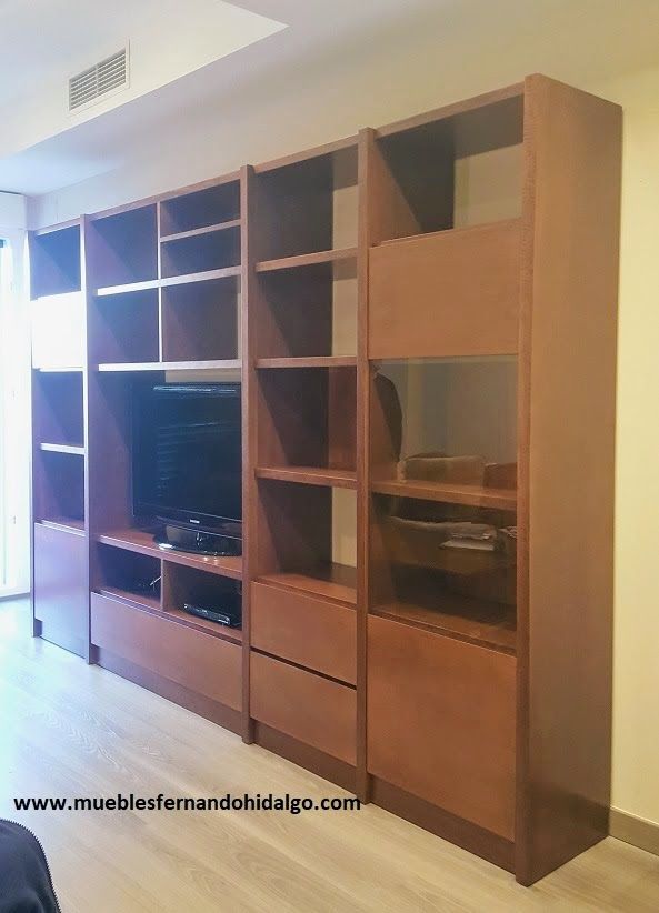 Un gran centro de entretenimiento de madera con estantes y cajones en una sala de estar.