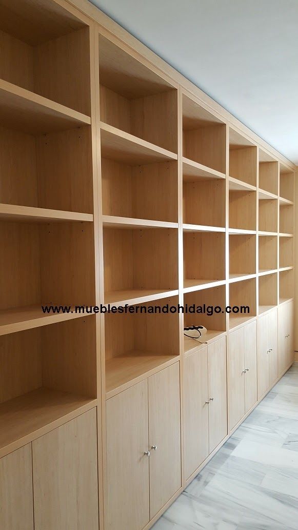 Una habitación con muchos estantes y armarios de madera.