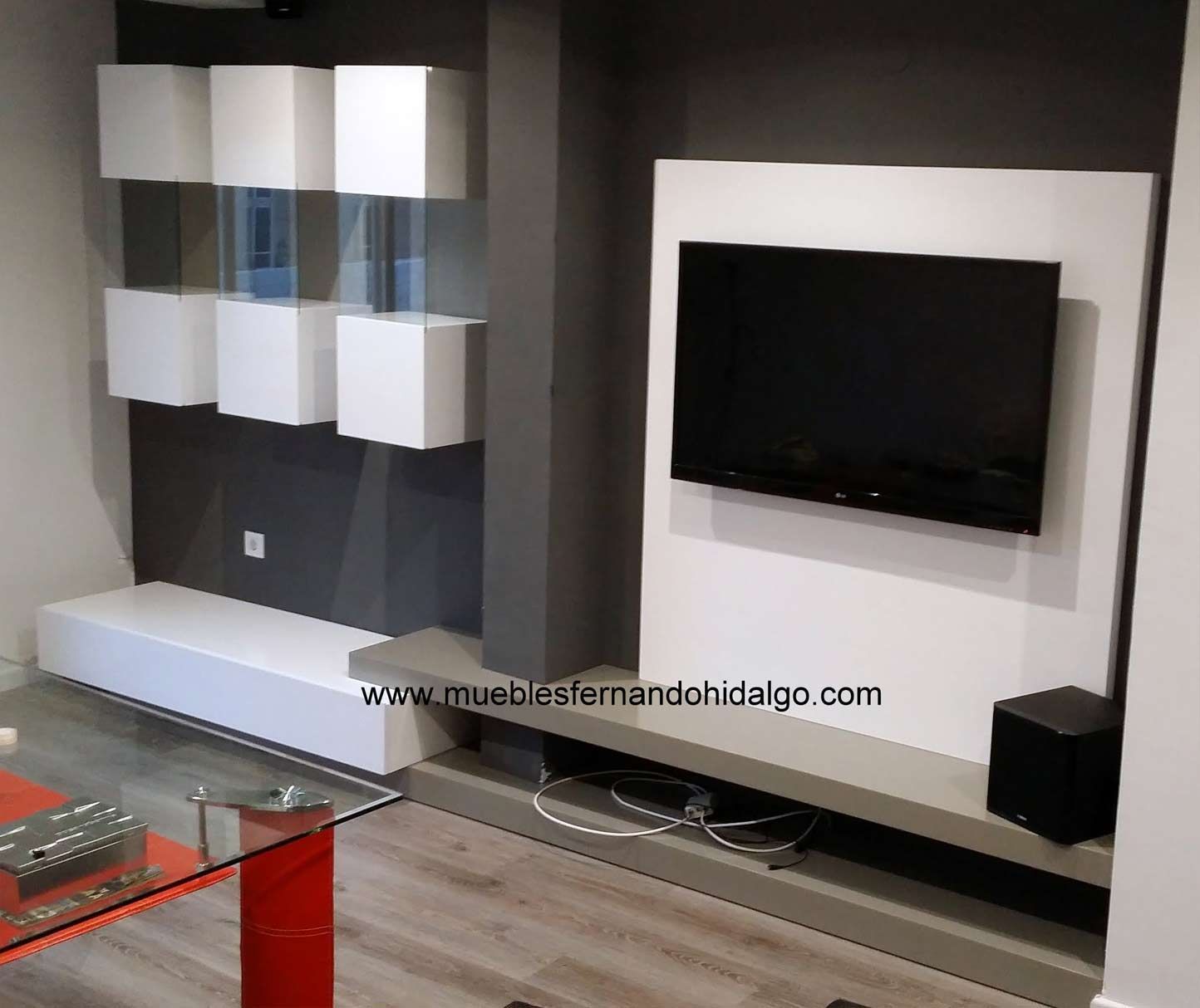 Una sala de estar con un televisor de pantalla plana y una mesa de café de cristal.