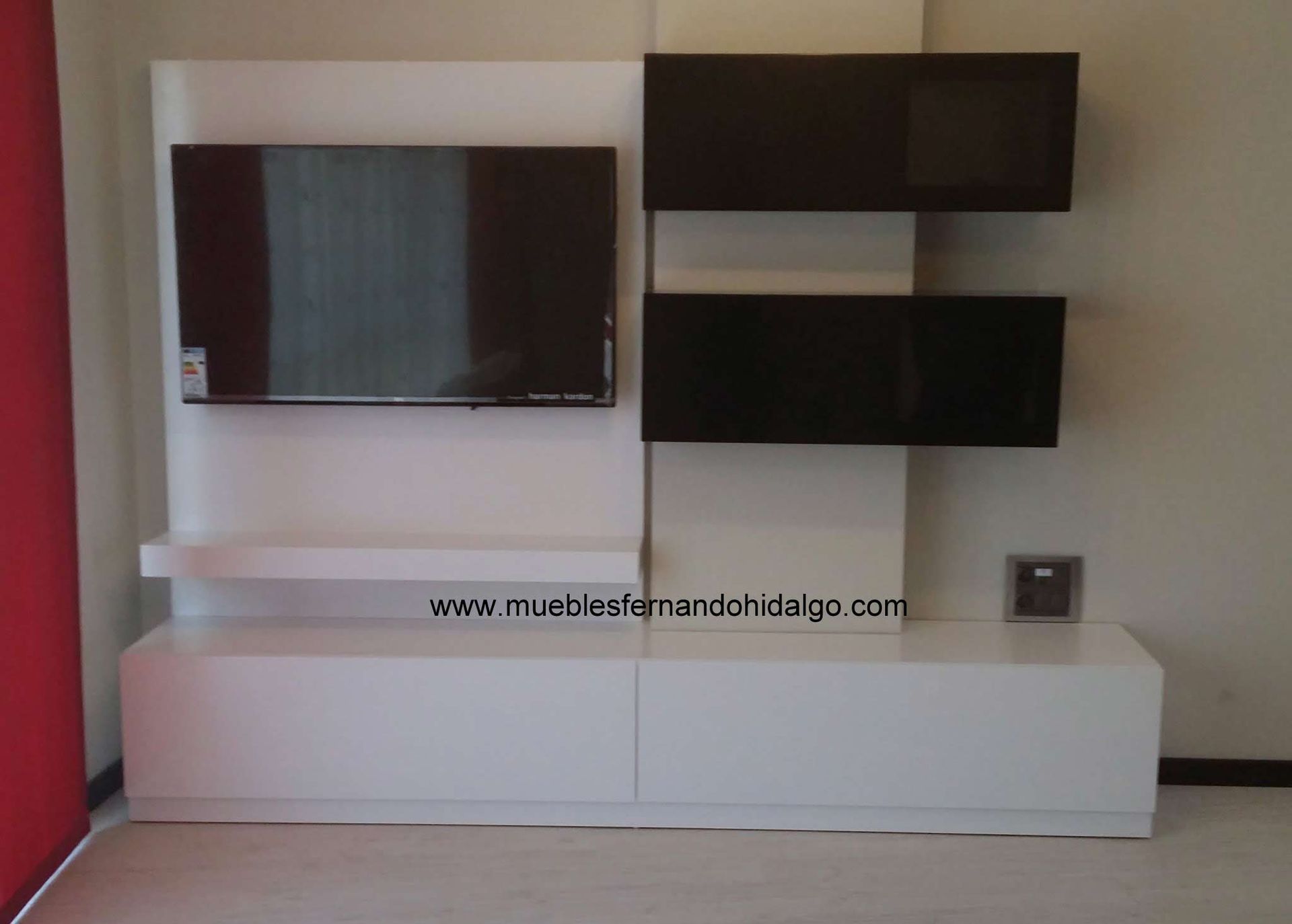 Un centro de entretenimiento blanco con un televisor de pantalla plana.