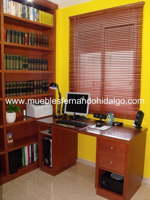 Una computadora está en un escritorio frente a una ventana con el sitio web www.mueblesfernandohidalgo.com escrito en la parte inferior