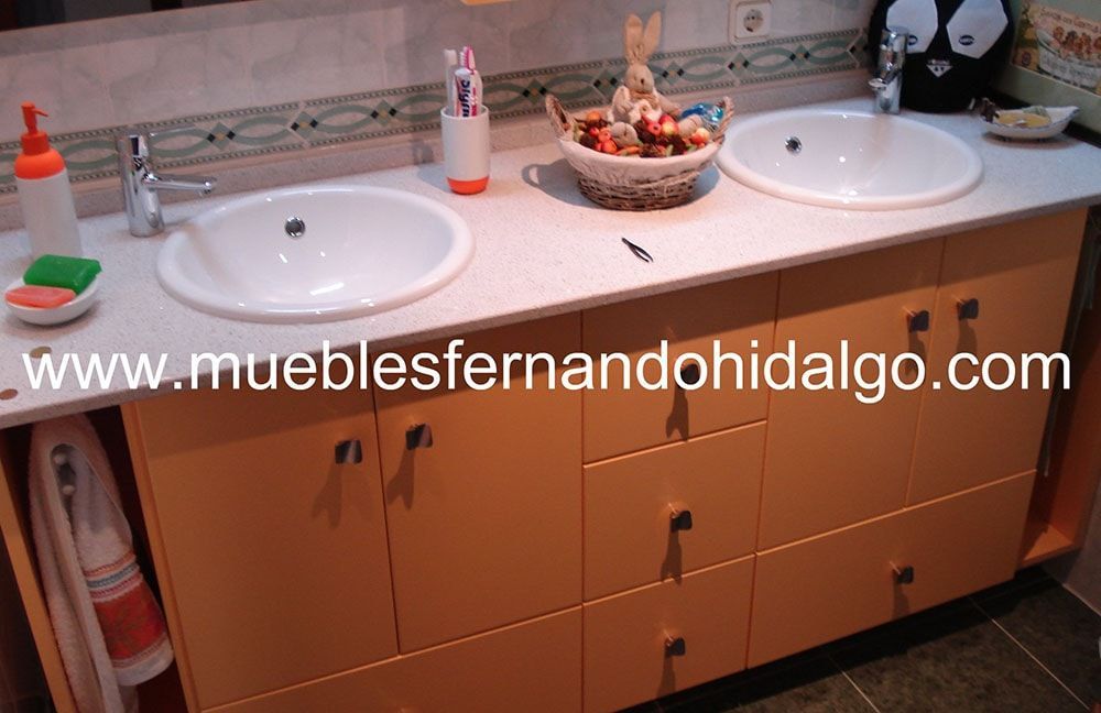 Un baño con dos lavabos y la web www.mueblesfernandohidalgo.com
