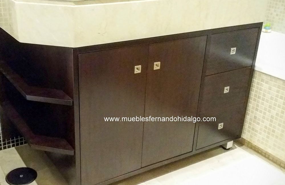 Un tocador de baño con encimera de mármol y gabinetes de madera.