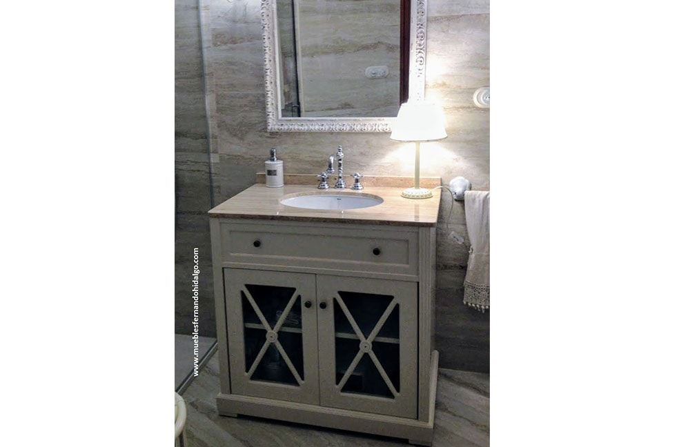 Un tocador de baño con lavabo, espejo y lámpara.