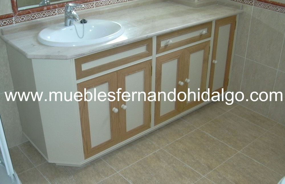 Un baño con lavabo y armarios y la web www.mueblesfernandohidalgo.com