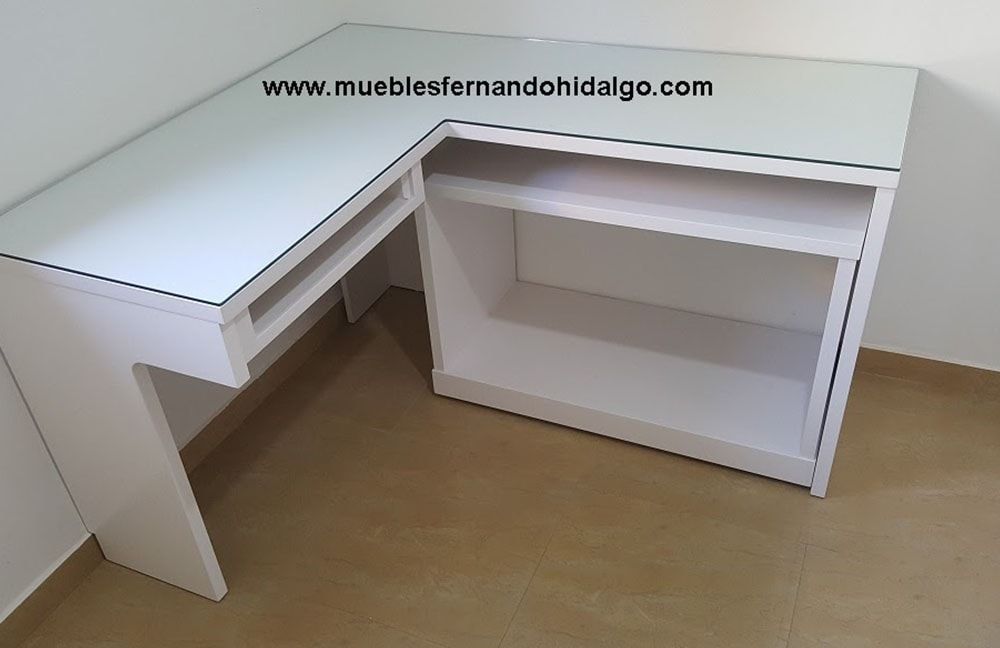 En una habitación hay un escritorio blanco en forma de L con tapa de cristal.